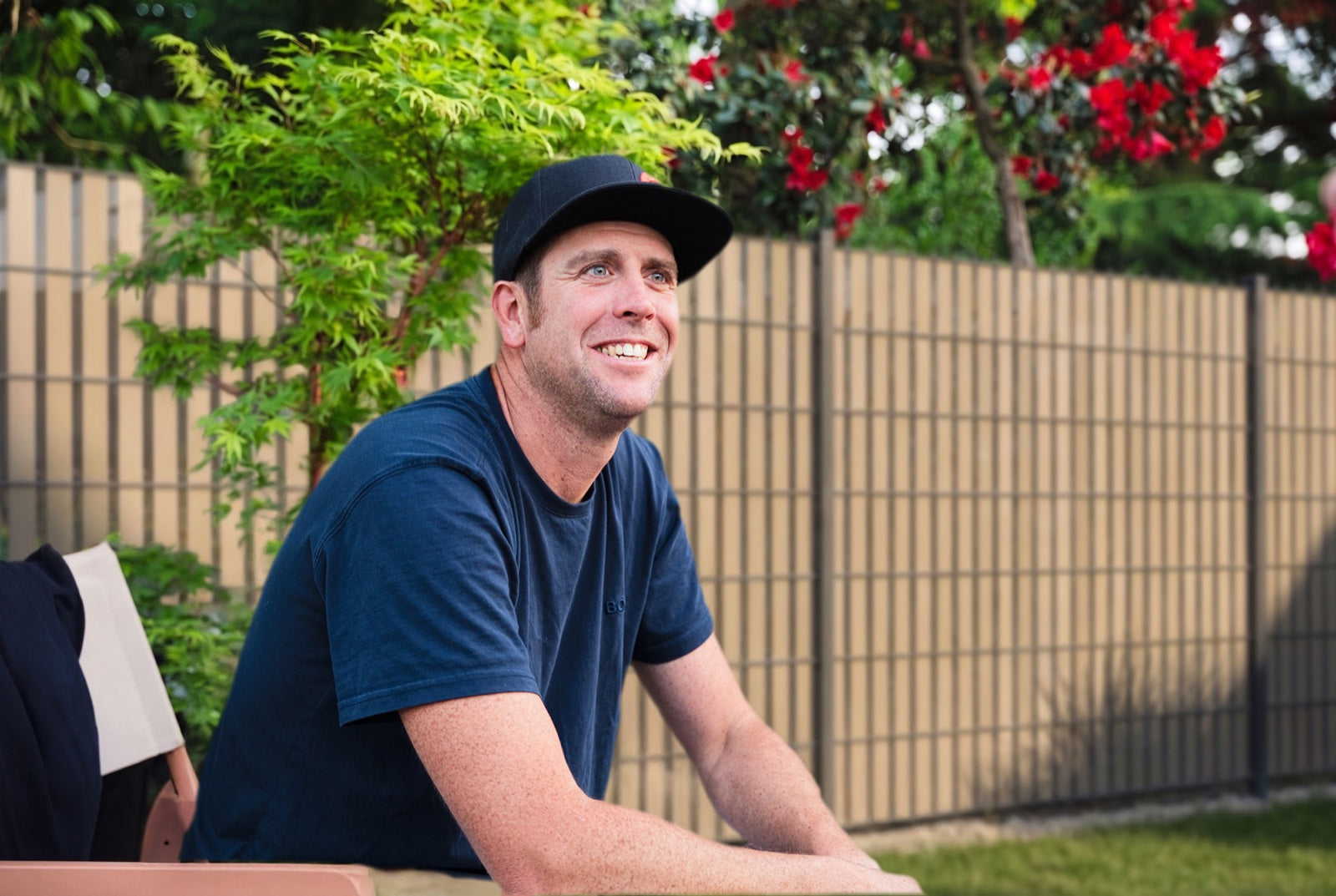 Christian A. Bergs im Garten vor einer Doppelstabmatte mit vertikalen Streifen.